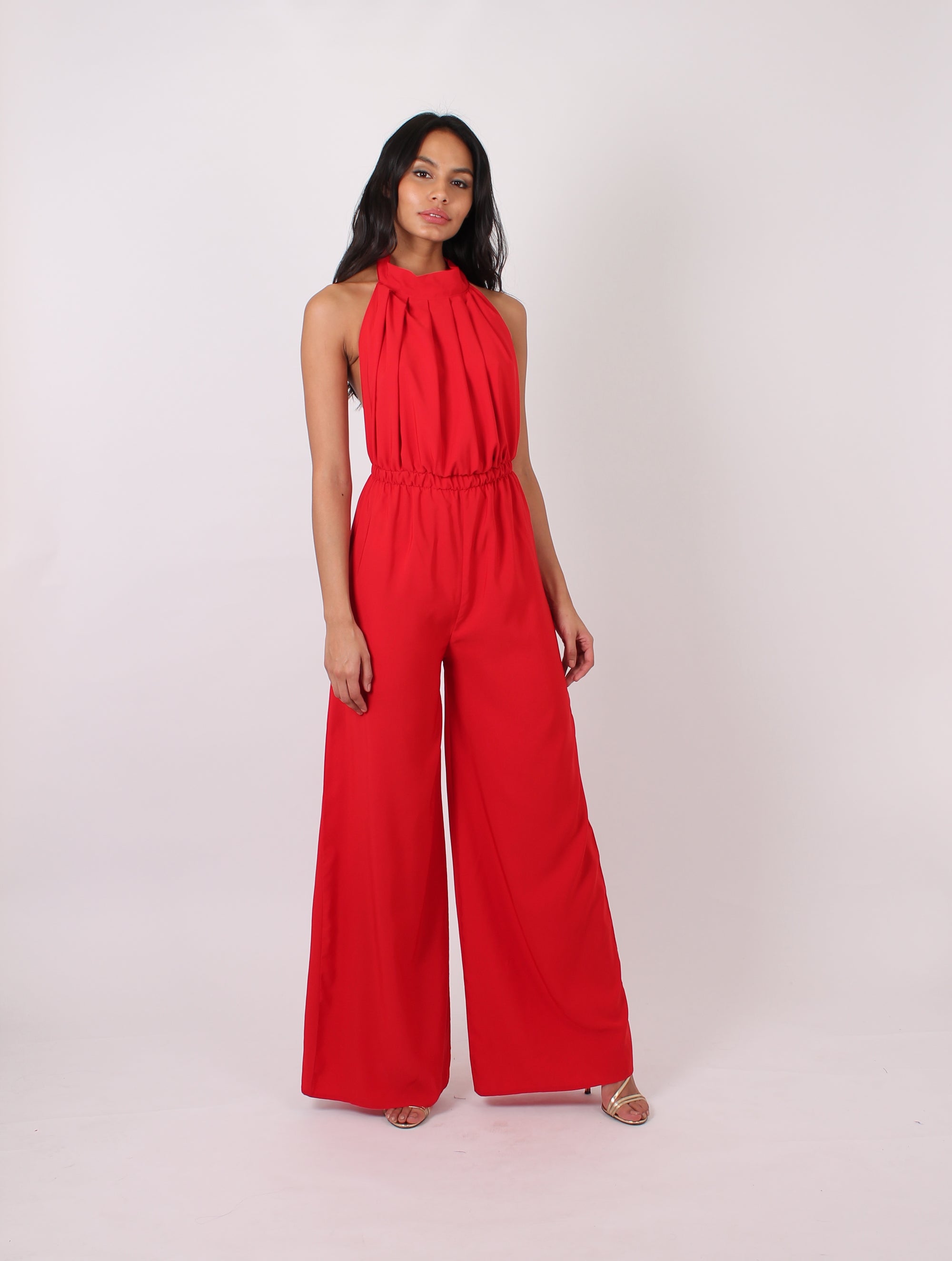 red backless jumpsuit with wide legs and a halter neck